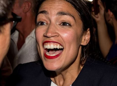 A person with dark hair and red lipstick smiling widely in a crowded setting.