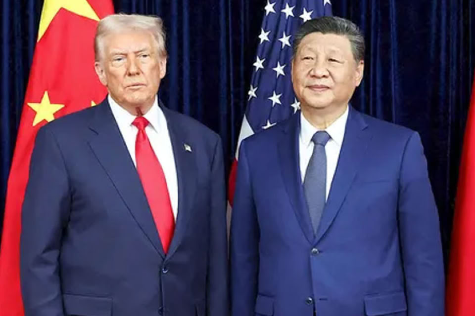 Two men in suits stand side by side in front of a backdrop featuring multiple red flags with yellow stars.